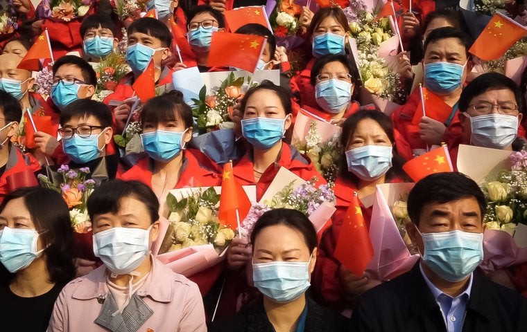 Image of multiple people wearing red wearing Covid-19 face masks