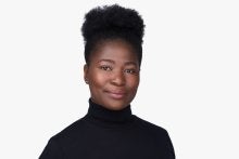 Photo of Black woman in black turtleneck with hair pulled back from her face.