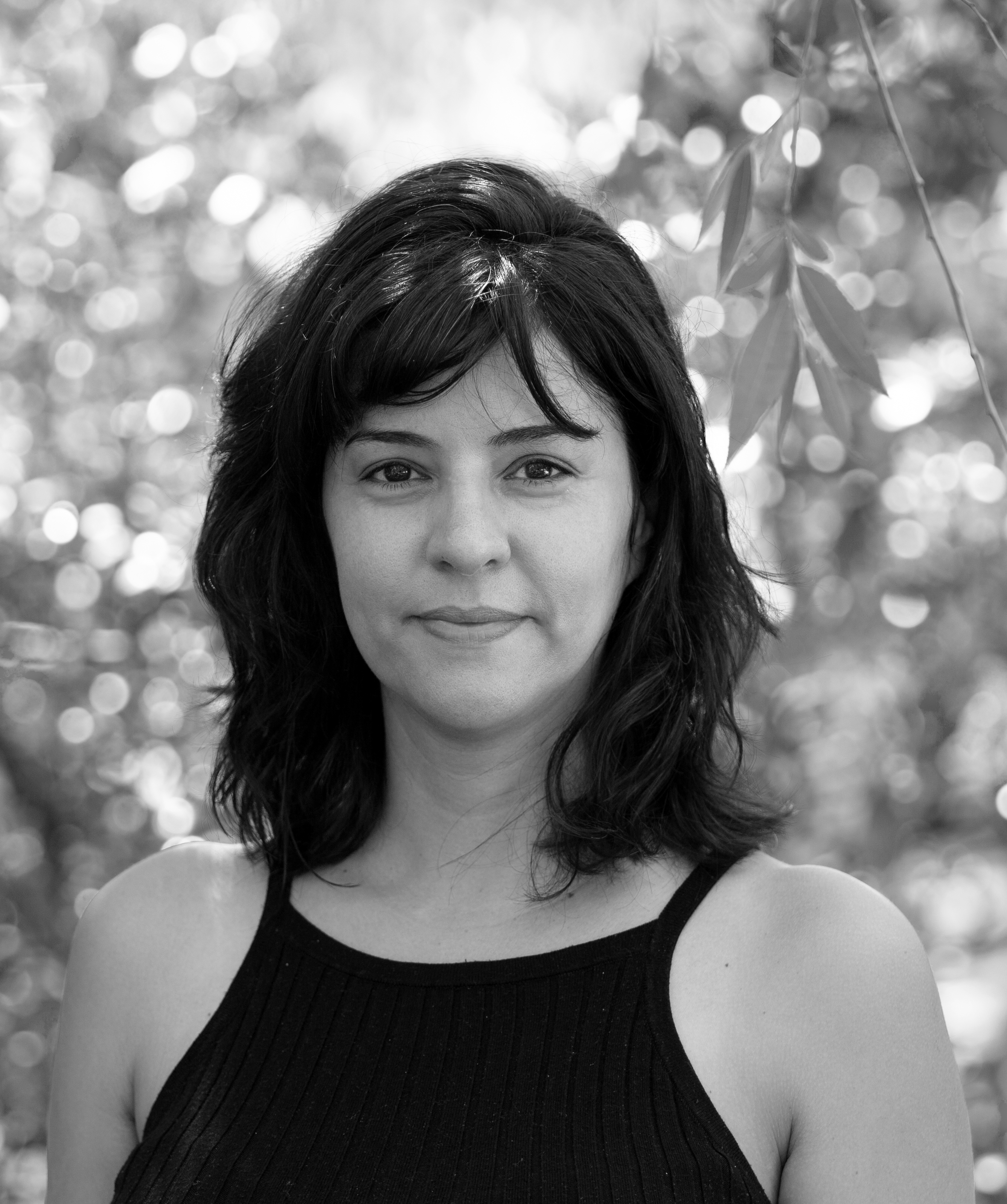 Black and white photo of woman smiling at camera with short dark hair