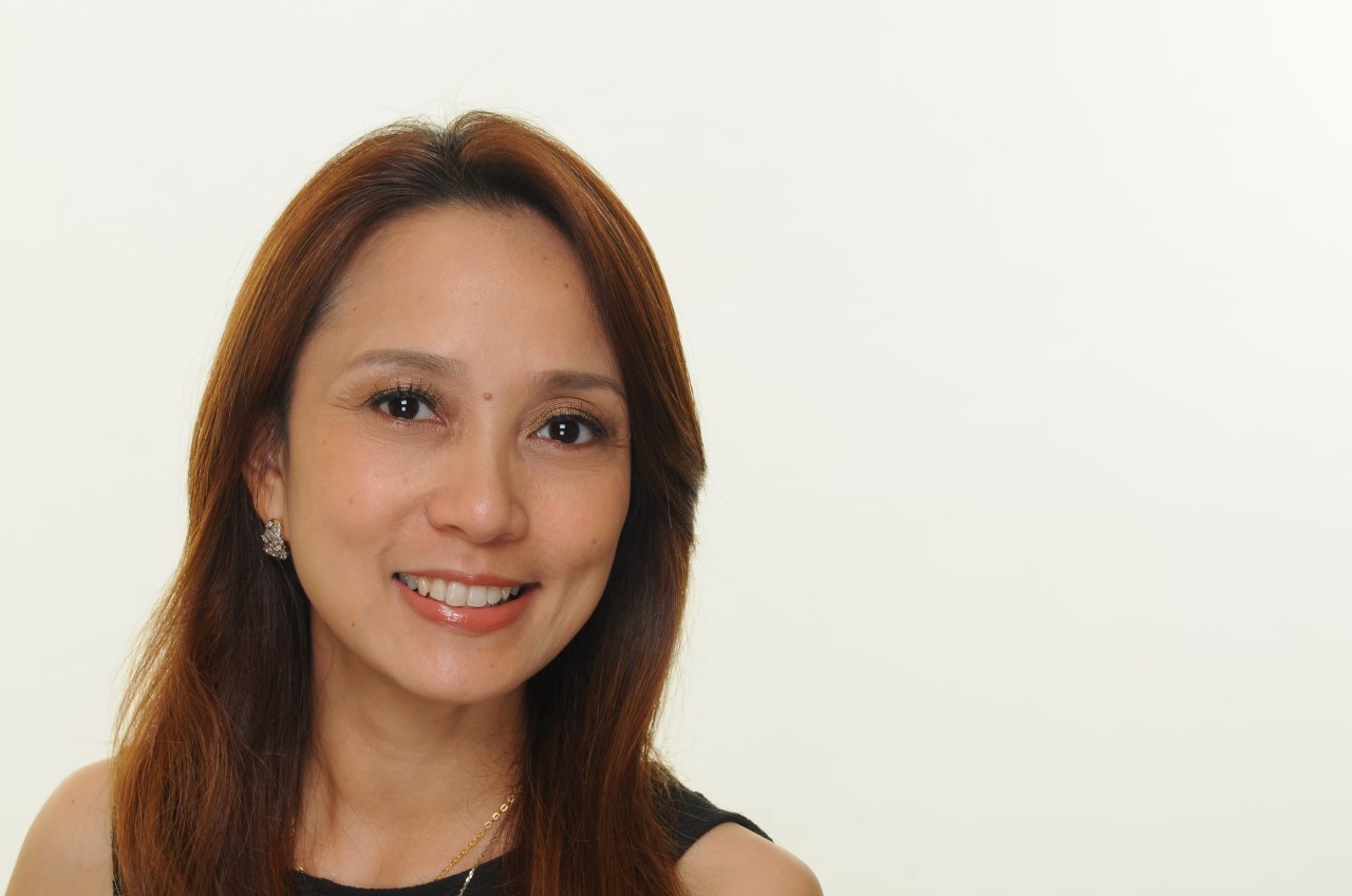 A woman with shoulder length brown hair smiles 