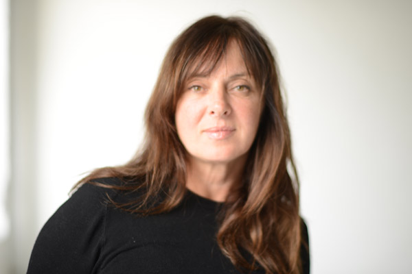 Image of woman with long brown hair and black top. 