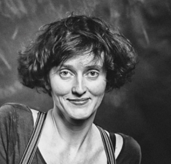 Black and white photo of white woman with cropped hair and bangs, smiling