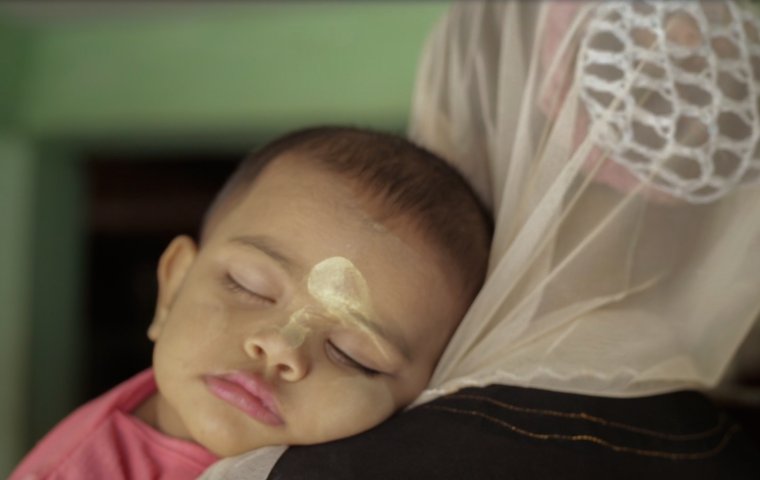 Image of a baby's sleeping face on a woman's shoulder