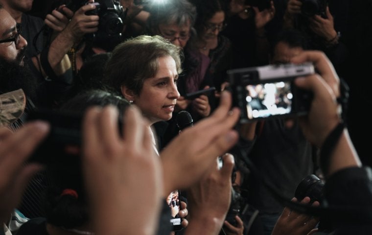 Carmen Aristegui surrounded by cameras and press