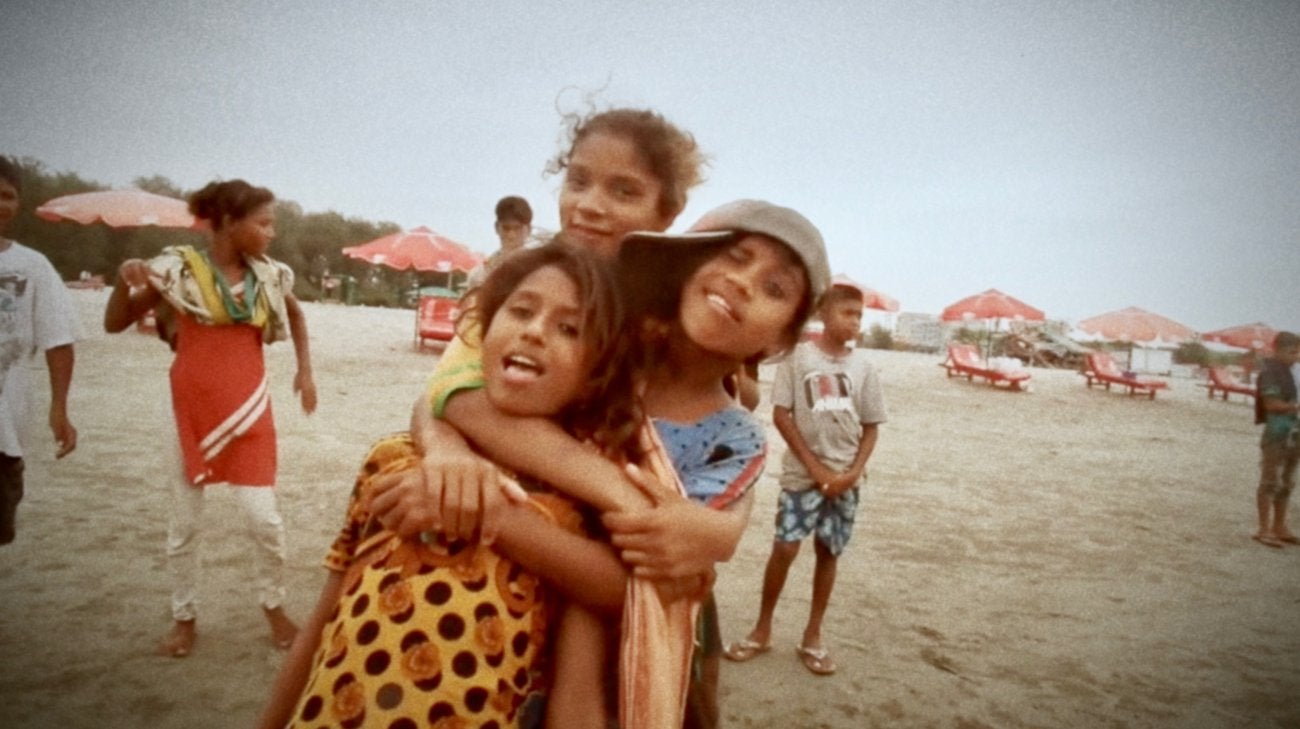 The girls hug each other and pose on the beach, celebrating their friendship..