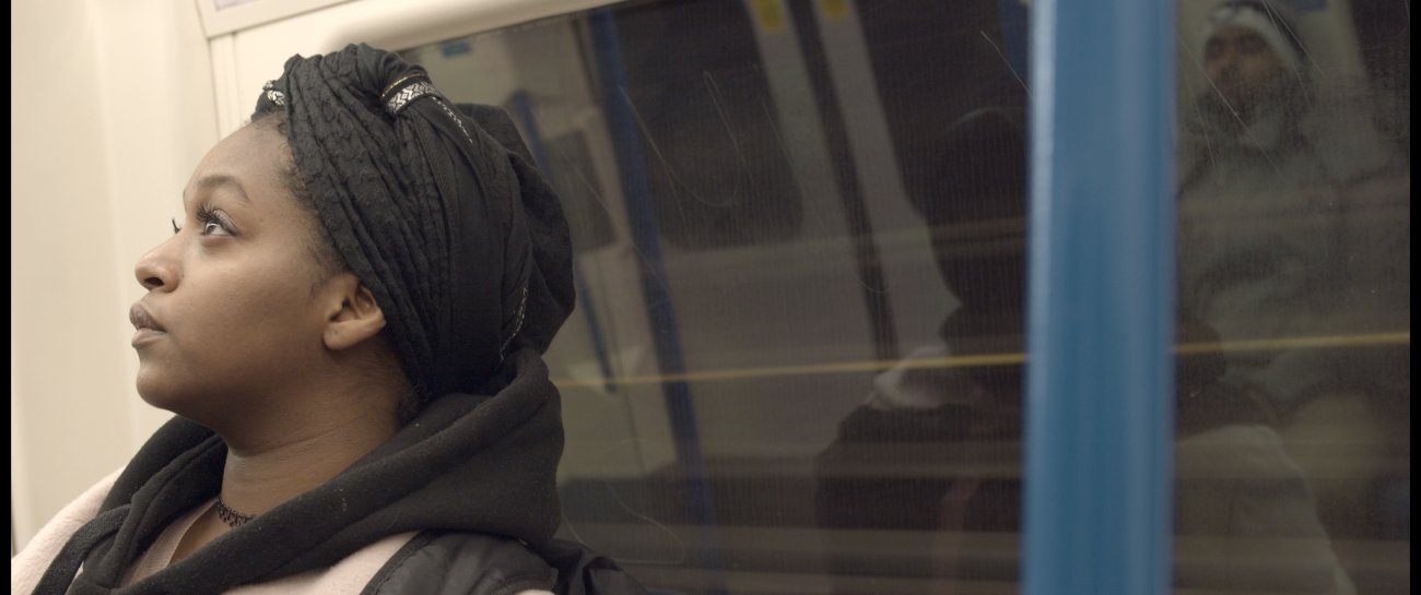 Image of Black woman with headwrap riding tube - looking towards the sky