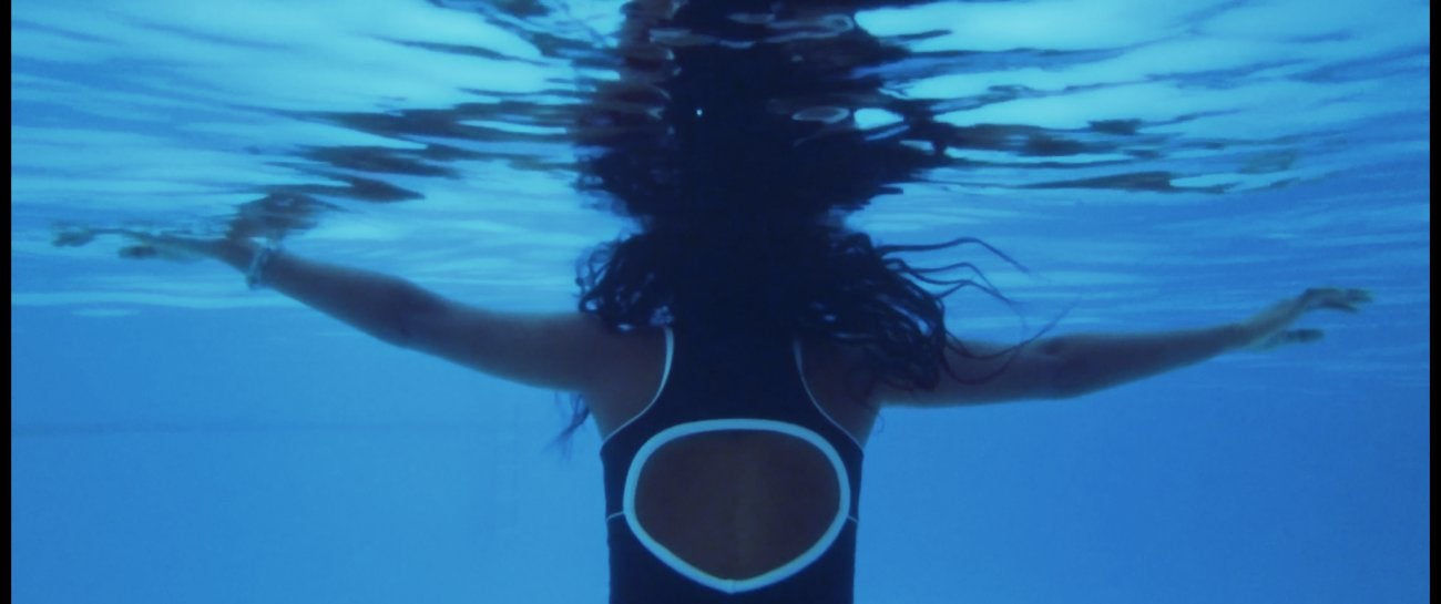 Image of woman as seen from the back under water.