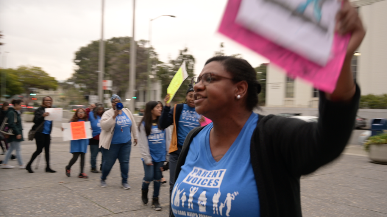 Photo of Clarissa in front of protest line in blue tshirts