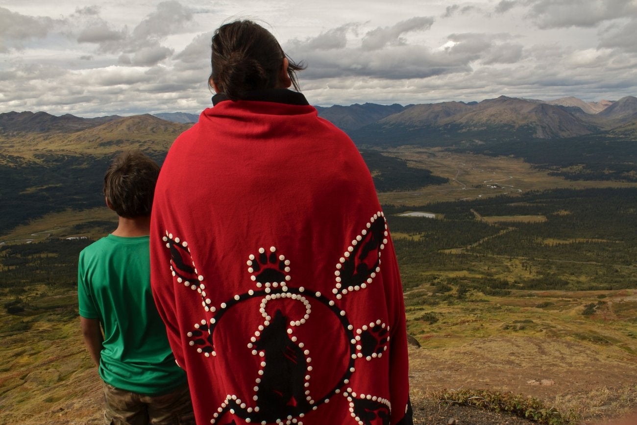 Photo of the back of an Indigenous woman, Rhoda Caden on Mt Klappen