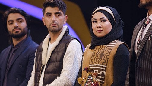 Image of singer finalists on TV show Afghan Star, with female singer at edge of frame, waiting for results to be called.