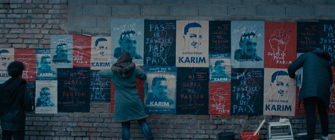 Wall of posters with "Justice for Karim" in French