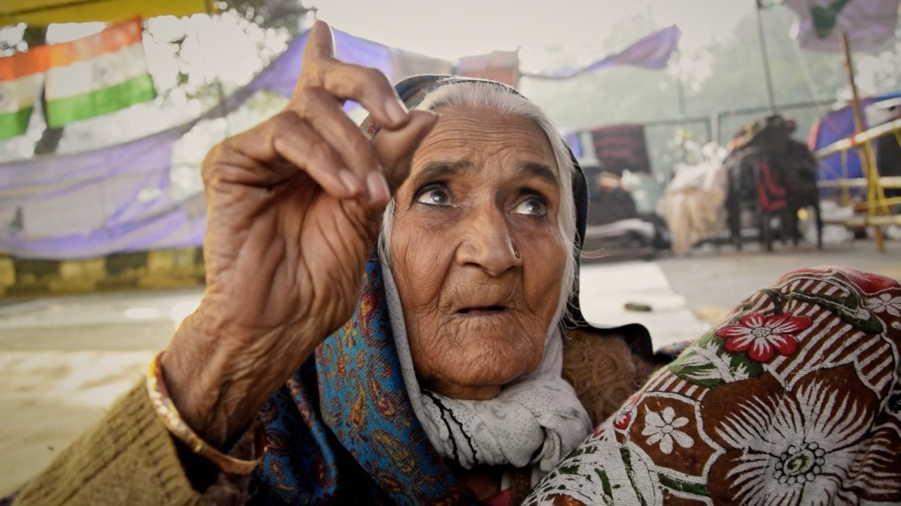 close-up of older indian lady, raising her finger above her face