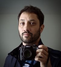 Man with facial hair holding camera