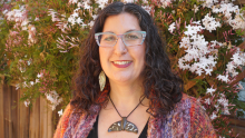 Woman with brown curly hair and glasses